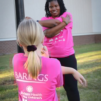 Girls on the Run coach and participant doing arm stretches